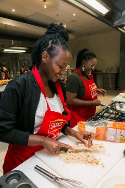 Johannesburg, Güney Afrika - 05 Ekim 2017: Genç Afrikalı kadınlar yemek pişirme ve pişirme kursunda öğreniyor