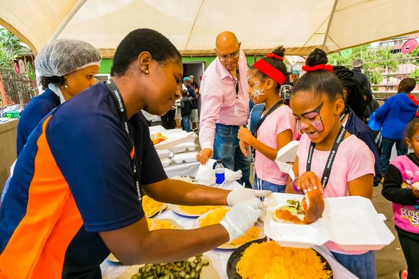 Johannesburg, Güney Afrika - 24 Mart 2018: Çorba Mutfağı Topluluğu Yemek Hizmetleri personeli Afrikalı çocuklara yemek dağıtıyor
