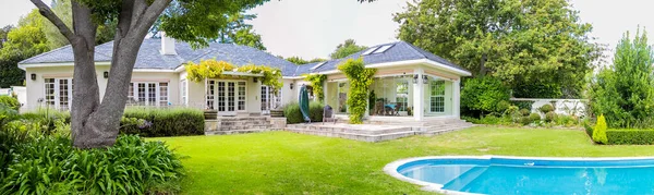 Upmarket 'in geniş açılı manzaralı zengin banliyö malikanesi manzaralı bahçe ve yüzme havuzlu