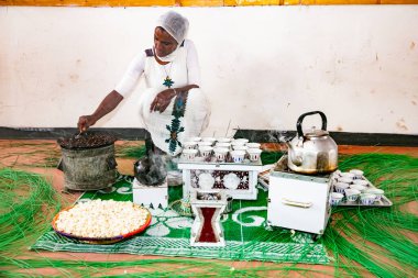 Addis Ababa, Etiyopya - 30 Ocak 2014: Afrikalı kadın geleneksel kahve ayini için tavada fasulye kızartıyor 