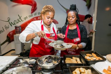 Johannesburg, Güney Afrika - 05 Ekim 2017: Genç Afrikalı kadınlar yemek pişirme ve pişirme kursunda öğreniyor