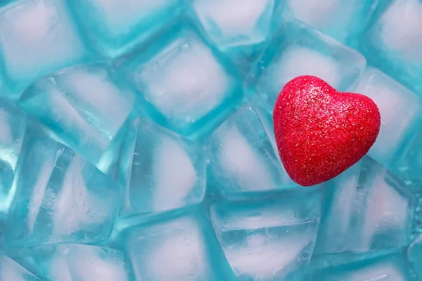 red heart on ice cubes, frozen cold heart concept, symbol of love