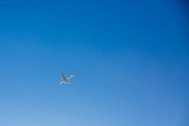 Yolcu uçak ek yükü açık mavi gökyüzü arka plan hiçbir bulutlar ile uçar. Alt görünümü