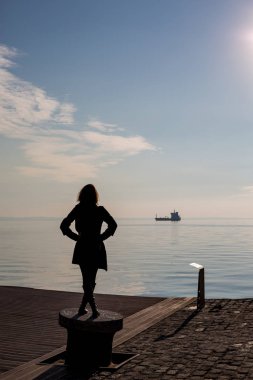 Genç güzel dans arkadan görünüm, Selanik, Yunanistan yerleştirme kutup kısa saçlı kadın uygun. Mavi deniz ve gökyüzü ve gemi içinde belgili tanımlık geçmiş arkadan görünüş