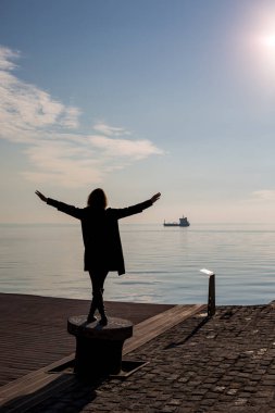 Genç güzel dans arkadan görünüm, Selanik, Yunanistan yerleştirme kutup kısa saçlı kadın uygun. Mavi deniz ve gökyüzü ve gemi içinde belgili tanımlık geçmiş arkadan görünüş