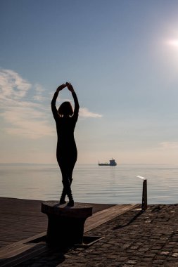 Genç güzel dans arkadan görünüm, Selanik, Yunanistan yerleştirme kutup kısa saçlı kadın uygun. Mavi deniz ve gökyüzü ve gemi içinde belgili tanımlık geçmiş arkadan görünüş