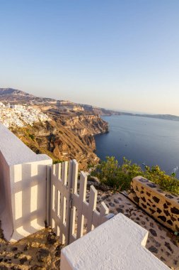 Santorini yükseltilmiş romantik sahnede. Yukarıdaki üzerinden, Fira, Yunanistan. Gündüz kısmi görünümü adanın renkli başkenti doğru şaşırtıcı. Kısa bir süre önce günbatımı ile ahşap beyaz kapı önünde
