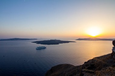 Santorini üzerinde yükseltilmiş inanılmaz romantik günbatımı sahne. Yukarıdaki üzerinden, Fira, Yunanistan. Şaşırtıcı altın saat görünümden genel yolu yürüyüş volkan caldera ortasına doğru. Gün batımından önce kısa bir süre