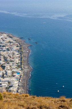 Santorini yükseltilmiş manzara olay yerine. Yukarıdaki üzerinden, Kamari, Yunanistan. Renkli şehir ve kumsalı ve sabah denize doğru şaşırtıcı gündüz kısmi görünümü