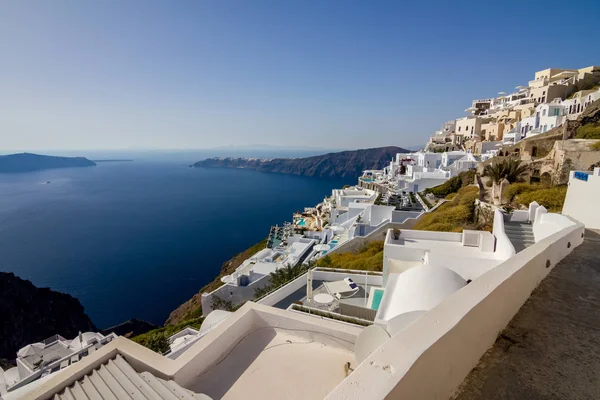 Görünümü ile inanılmaz romantik bir sahne, Santorini Teras. Fira, Yunanistan. Oia ve derin deniz kristal suları beyaz evleri ve yüzme havuzları ile muhteşem gündüz cityscape