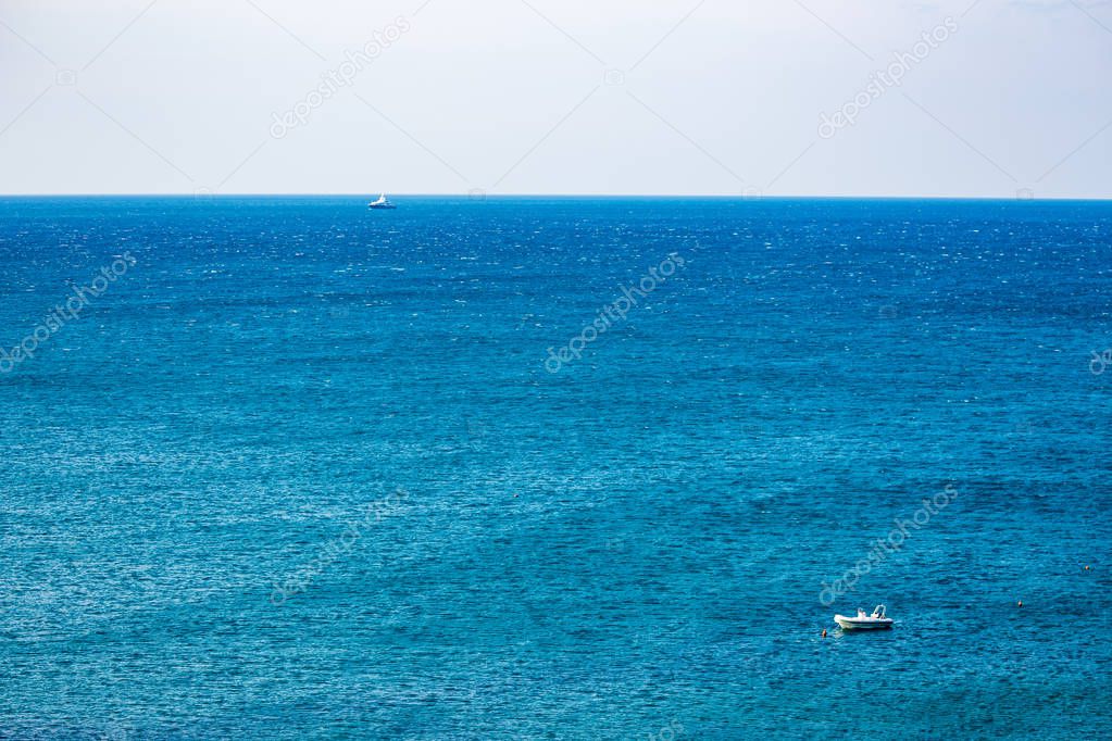 Two boats in the blue waters of Adriatic Sea in a clear but windy spring day, focus on the back boat. Calm scene, crystal background