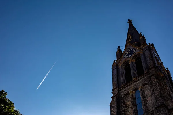 Blå himmel med flygplan trail och katedralen front — Stockfoto