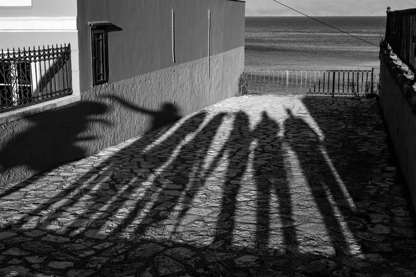 Μακρύ απόγευμα σκιές επτά άνθρωποι και θάλασσα — Φωτογραφία Αρχείου