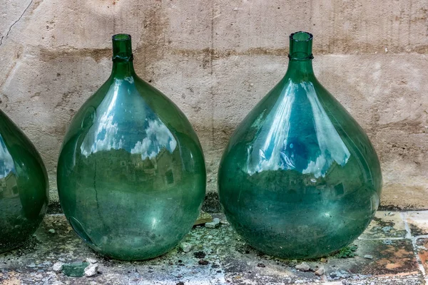 Large green glass wine jars in Matera, Italy