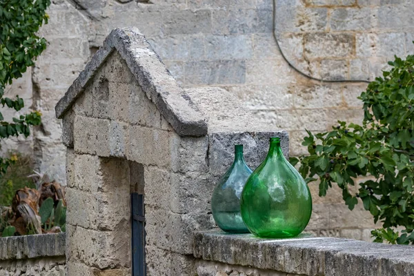 Large green glass wine jars in Matera, Italy