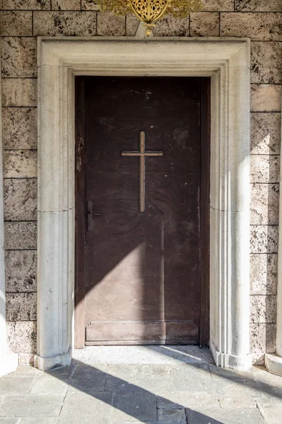 Old wooden church door with cross Batkun monastery