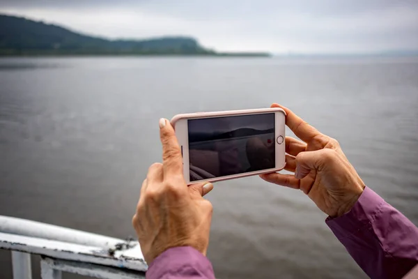 Mujer manos sosteniendo teléfono de grabación de vídeo de lago — Foto de Stock