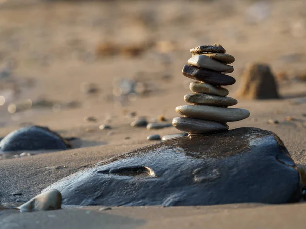 Balance of stones on a large stone near the sand