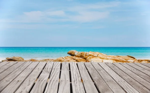 白砂のビーチを望む空の木製桟橋 テキストまたは製品の配置のための空きスペース 夏の休日の背景 シュロの葉 ふわふわの雲 青い海 白い砂 熱帯のビーチ — ストック写真