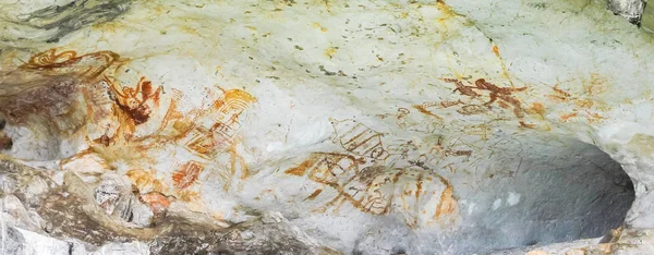 Archaeological pre-historic human cliff paint over 3,000 years ago, khao-khian-ao-phang-nga-national-park, Thailand. Cave paintings of primitive man on sand stone. ocher paint.