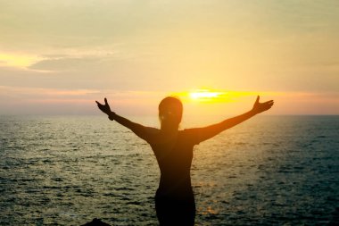 Sessiz doğadaki Asya güzel kız silüeti. Arka planda bir turuncu günbatımı mı