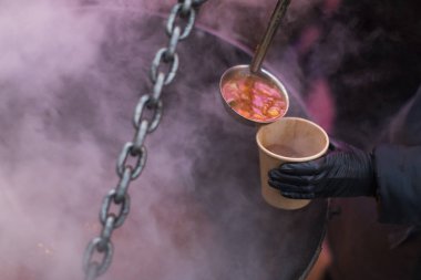 Bir kişi bir fincan çorba dökme.