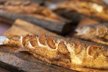 Mor bir masa örtüsü üzerinde ahşap bir tahta üzerinde balık füme