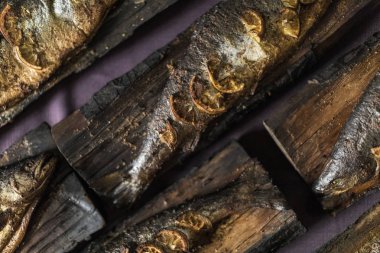 Mor bir masa örtüsü üzerinde ahşap bir tahta üzerinde balık füme