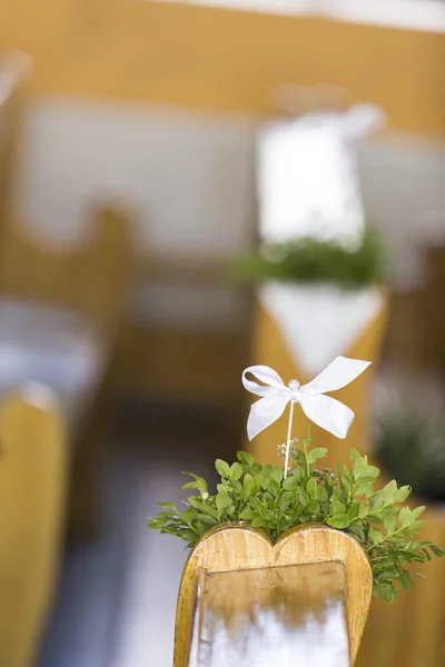 A small bouquet of flowers with a ribbon attached to a church be