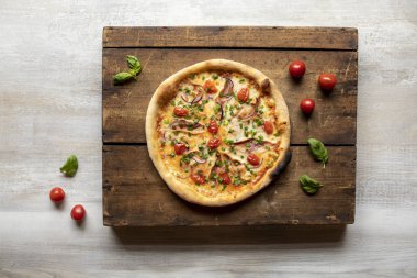 Et, peynir, kurutulmuş domates, taze soğan ve ahşap yüzeyde ekmek ile jambonlu pizza.