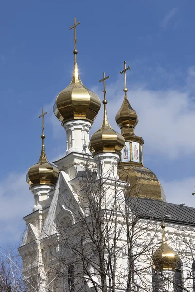 A part of a church with gold domes with a blue sky and white clouds in the background