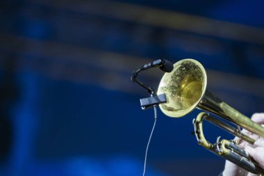 Bir konserde sahne ışıkları içinde belgili tanımlık geçmiş ile gerçekleştirme trompetçi