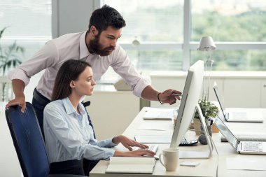 Erkek ve kadın bilgisayarı kullanmak ve proje tartışıyor modern ofis çalışma masasında yan görünüm