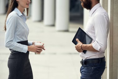 işadamı ile tablet ve ayakta dışında ve sohbet kahve fincanı kadınla