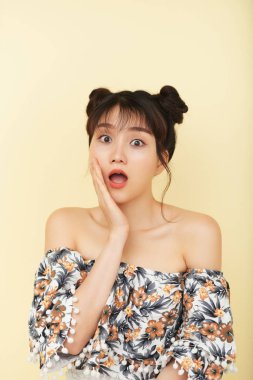 Açık ağız ve bej renkli arka plan üzerinde izole yanağına el ile sürpriz Asyalı kadın