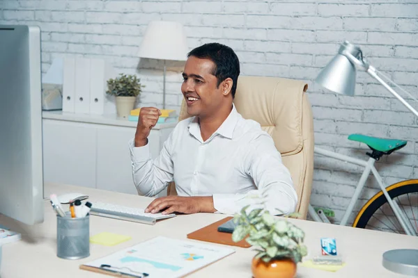 Indian Businessman Sitting Office Desk Looking Computer Monitor Celebrating Achievement — Stock Photo, Image