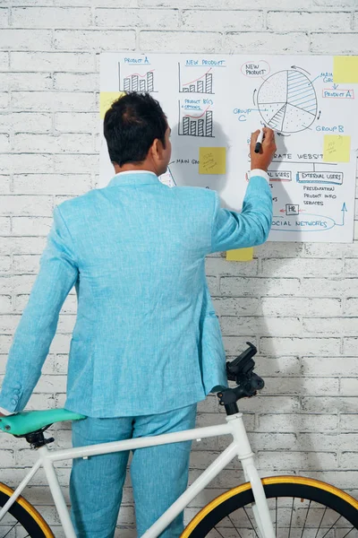 Widok Biznesmen Niebieski Garnitur Stojąc Roweru Rysowanie Wykresów Diagramów Papierze — Zdjęcie stockowe