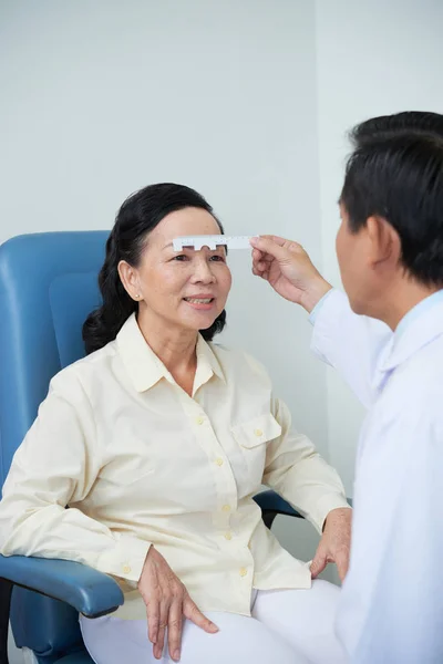 Médico Con Regla Especial Tomando Medidas Ojos Mujer Asiática Madura — Foto de Stock