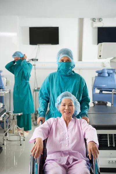 微笑的亚洲妇女坐在轮椅与医生在内阁 — 图库照片
