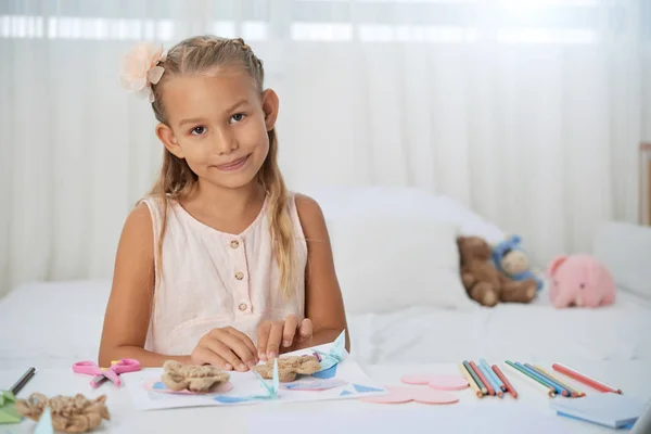 漂亮的微笑的女孩在桌子上用铅笔做创意项目 — 图库照片