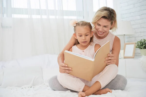 Sonriente Madre Leyendo Libro Hija Pequeña Cama Dormitorio —  Fotos de Stock