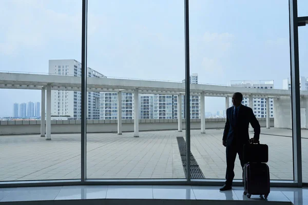 Silhouette Eines Geschäftsmannes Mit Gepäck Vor Riesigem Flughafenfenster — Stockfoto