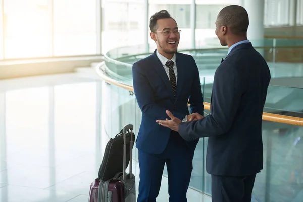 亚洲商人在机场候机楼会见非裔美国同事 — 图库照片