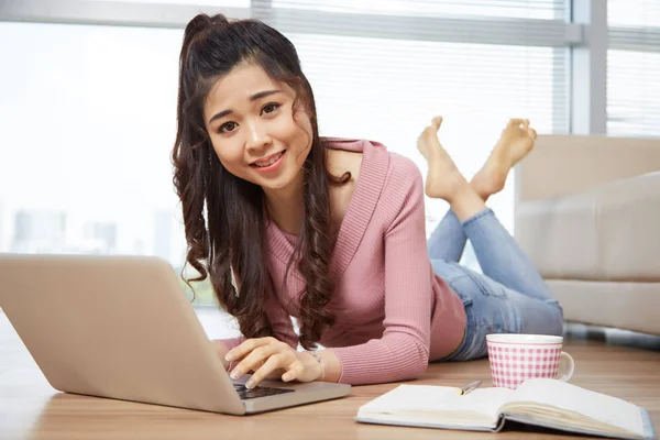 Glimlachend Vietnamese Vrouw Liggend Vloer Kamer Die Laptop Werkt — Stockfoto