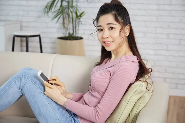 Asiático Sorrindo Mulher Sentado Sofá Smartphone — Fotografia de Stock