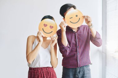 Erkek ve kadın çok güzel pozitif emoji kağıtları ile karşı karşıya kapsayan 