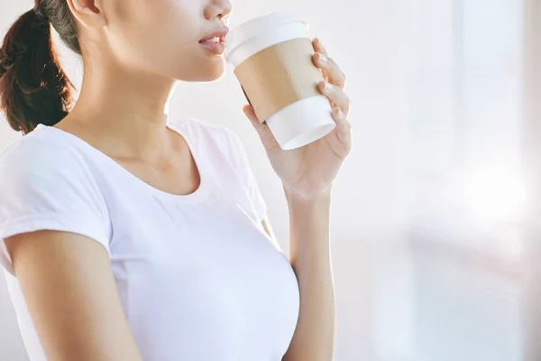 Side view of woman holding cup of coffee at mouth