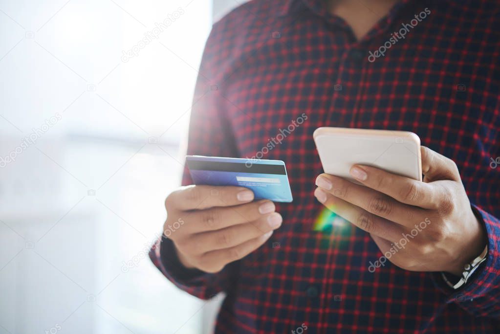 man doing purchase online via smartphone with help of credit card