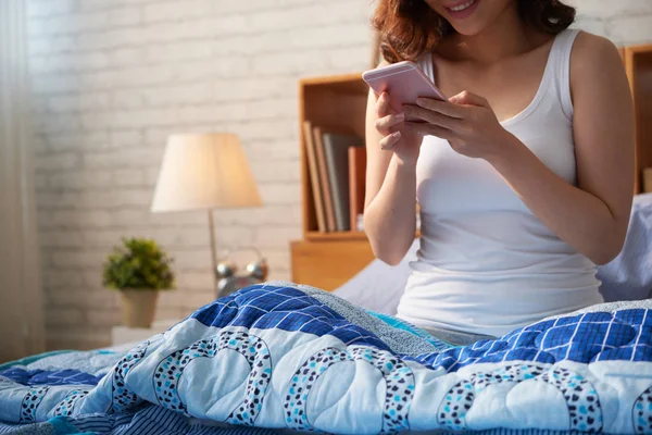 Cropped Image Young Woman Sitting Bed Checking Her Phone Morning — Stock Photo, Image