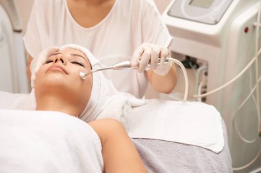 Yordam yüz cilt gençleştirme için rahatlatıcı spa salonu sahip genç istemci